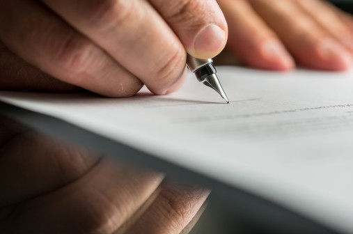 Person unterschreibt Vertrag. Une personne signant un contrat. Una persona firma un contratto.